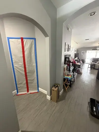 Zippered plastic containment door sealing off a wet room