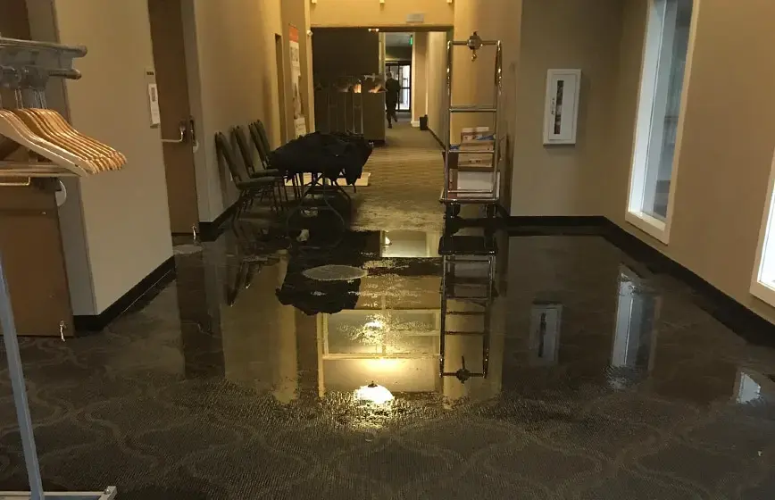 Standing water across a commercial hallway floor before extraction